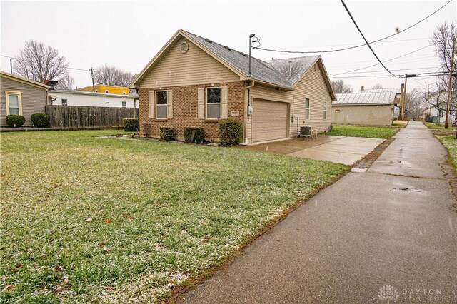 view of front of house with cooling unit, brick siding, fence, driveway, and a front lawn