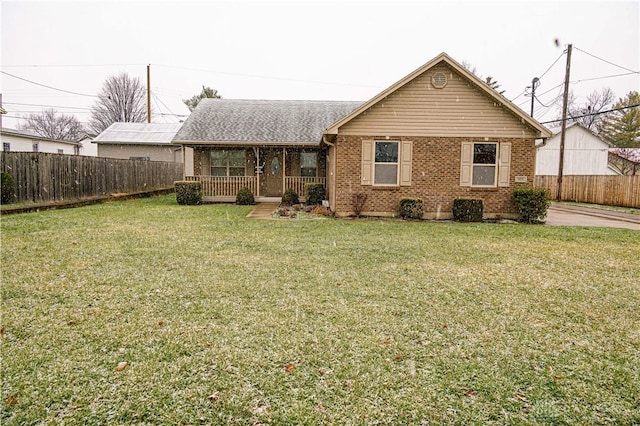 exterior space with covered porch, fence, a front lawn, and brick siding