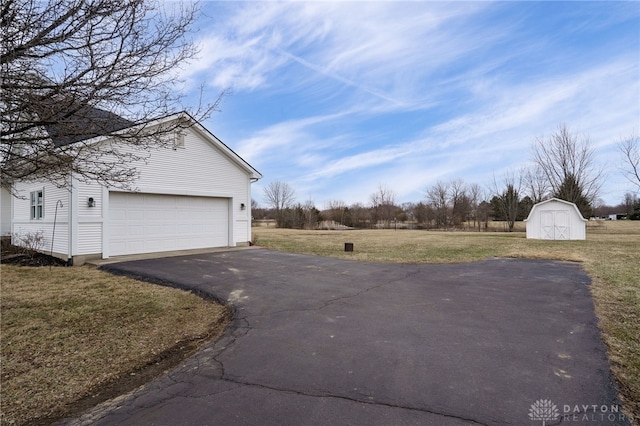 view of side of property featuring a garage, an outbuilding, a yard, and a shed