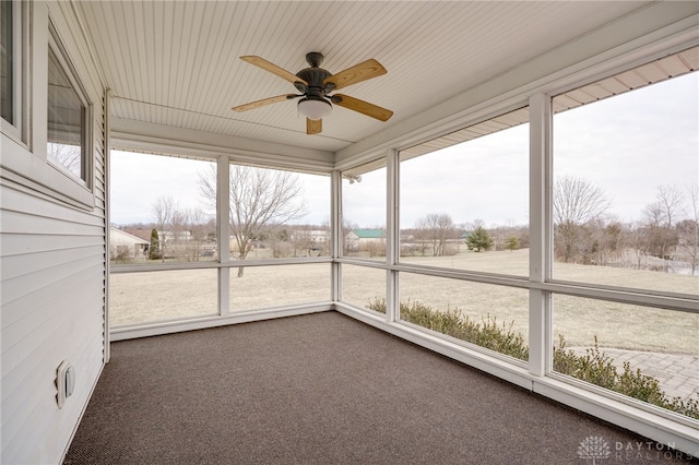 unfurnished sunroom featuring ceiling fan and a wealth of natural light