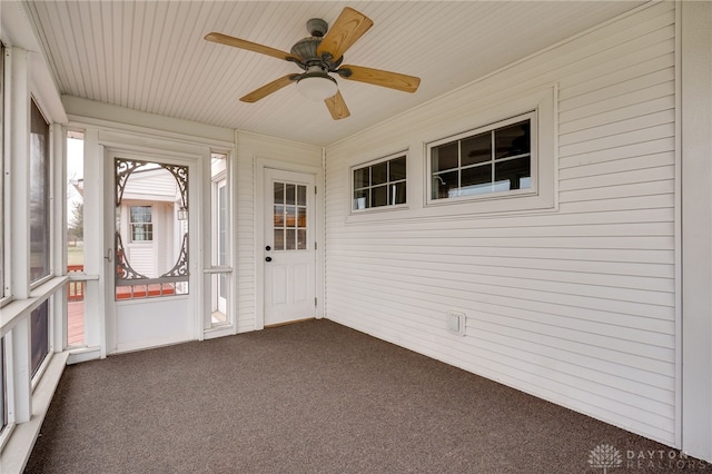 unfurnished sunroom with a ceiling fan