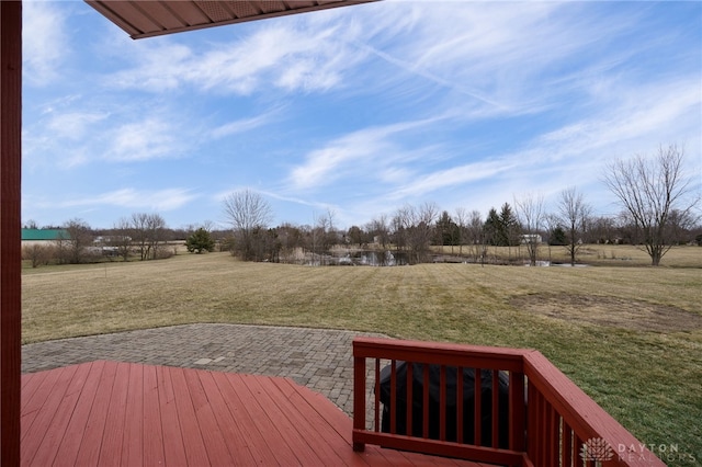 wooden deck featuring a lawn and a patio