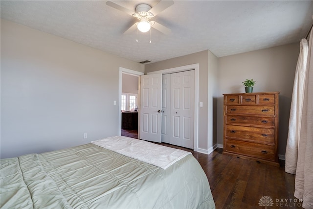 bedroom featuring visible vents, baseboards, dark wood-style floors, ceiling fan, and a closet