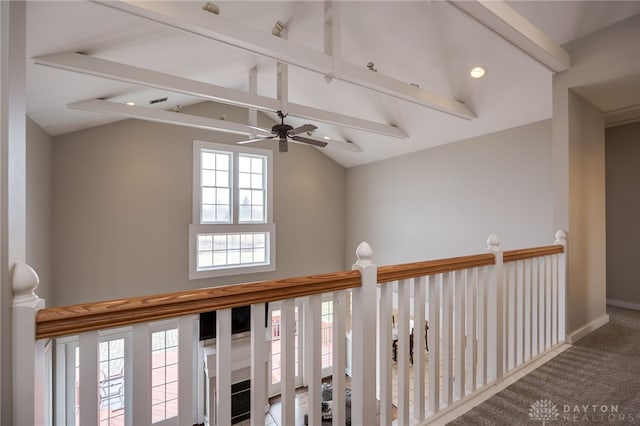 corridor with carpet floors, lofted ceiling with beams, and baseboards