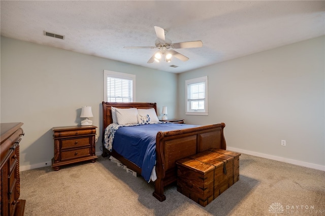 bedroom featuring light carpet, baseboards, visible vents, and a ceiling fan