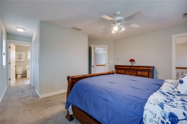 bedroom with visible vents, ensuite bathroom, light carpet, ceiling fan, and baseboards