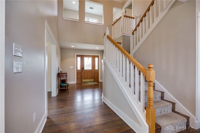 foyer entrance featuring recessed lighting, visible vents, a towering ceiling, baseboards, and wood-type flooring