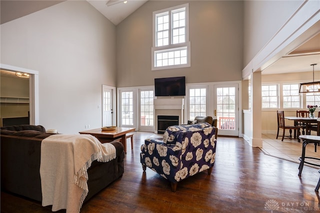 living room featuring a fireplace, high vaulted ceiling, dark wood finished floors, and a wealth of natural light