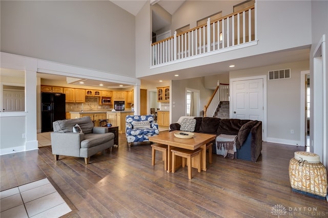 living room with visible vents, baseboards, wood-type flooring, stairs, and recessed lighting