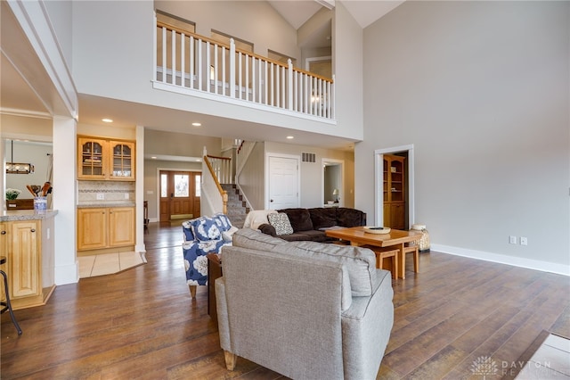 living area with recessed lighting, visible vents, baseboards, stairway, and dark wood-style floors