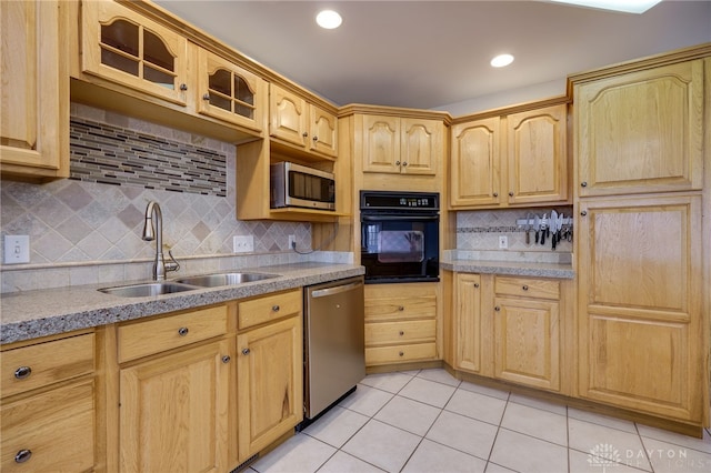 kitchen featuring light tile patterned flooring, stainless steel appliances, a sink, and light brown cabinetry