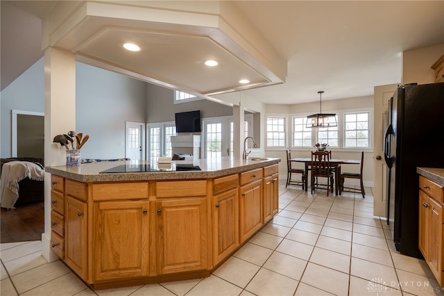 kitchen with black appliances, light tile patterned floors, pendant lighting, and a sink