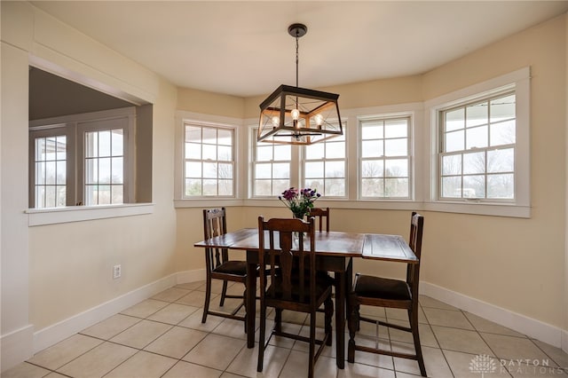 dining space featuring a notable chandelier, light tile patterned floors, and baseboards