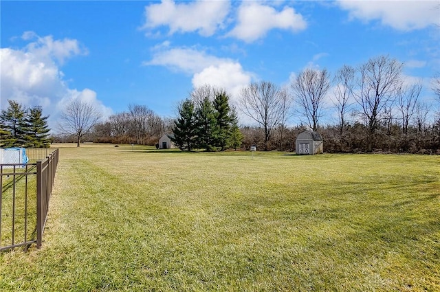 view of yard with an outdoor structure, a storage shed, and fence