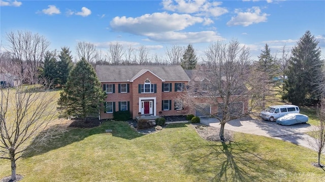 view of front of property featuring driveway, brick siding, and a front yard