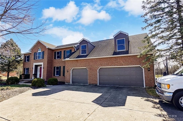 colonial home featuring concrete driveway, brick siding, roof with shingles, and an attached garage