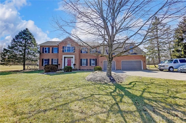 colonial home featuring driveway, brick siding, a garage, and a front yard