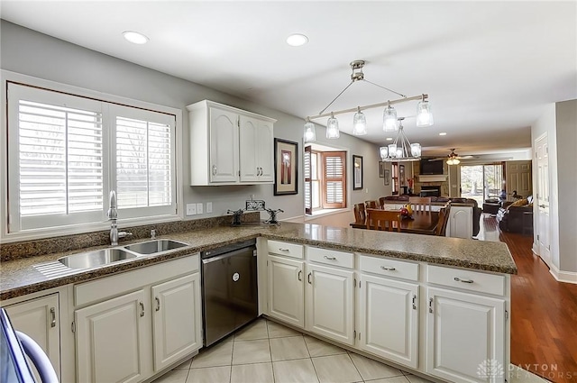 kitchen with dishwasher, a peninsula, a sink, and a healthy amount of sunlight