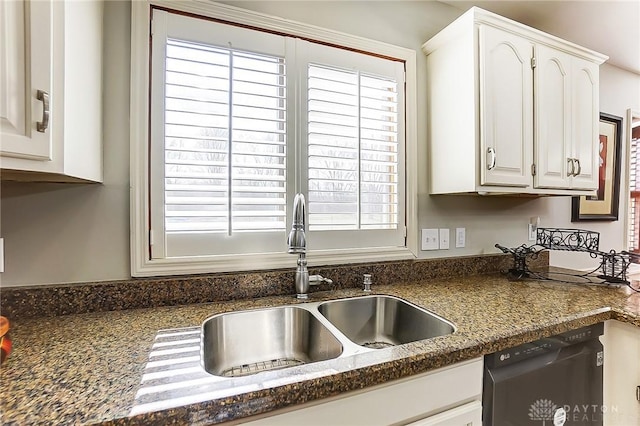 kitchen with dark countertops, dishwasher, and a sink