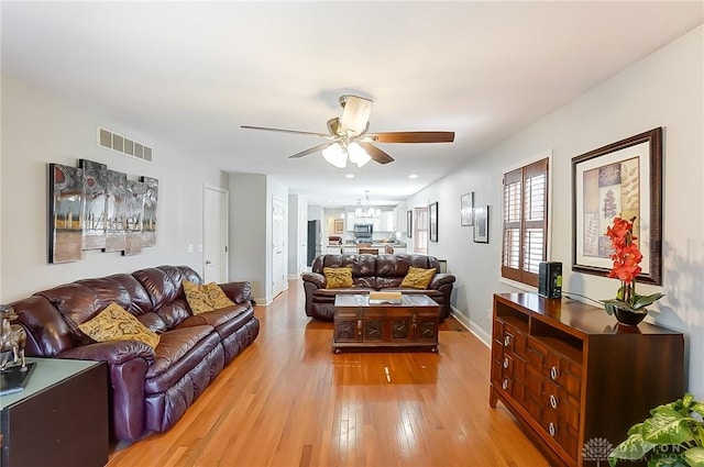 living area featuring visible vents, ceiling fan, light wood-style flooring, and baseboards