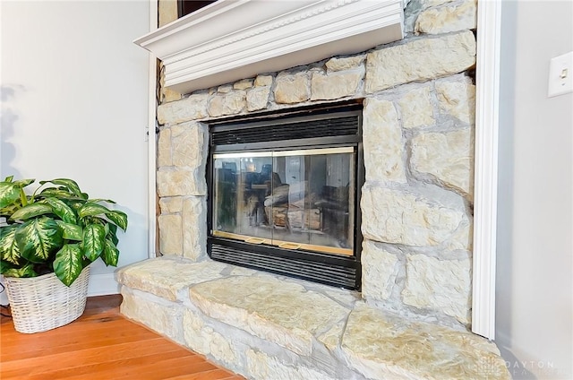 room details with wood finished floors and a stone fireplace