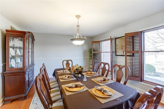 dining area with light wood-style flooring and baseboards