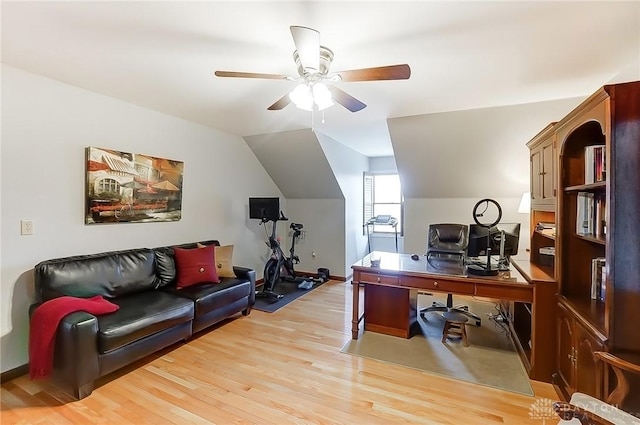 office space featuring lofted ceiling, baseboards, light wood-style flooring, and a ceiling fan