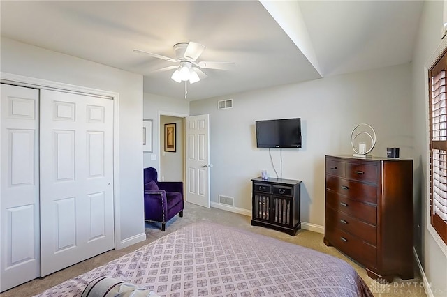 carpeted bedroom featuring a ceiling fan, a closet, visible vents, and baseboards