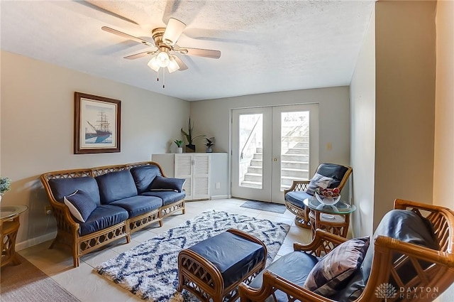 living room with ceiling fan, baseboards, a textured ceiling, and french doors