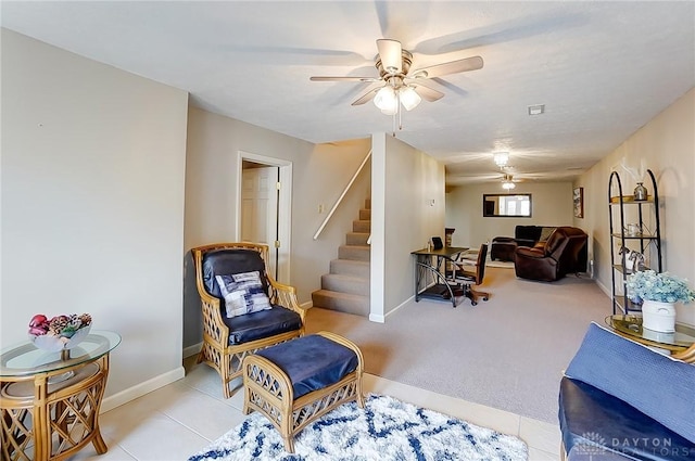 sitting room with light tile patterned floors, stairway, a ceiling fan, and baseboards