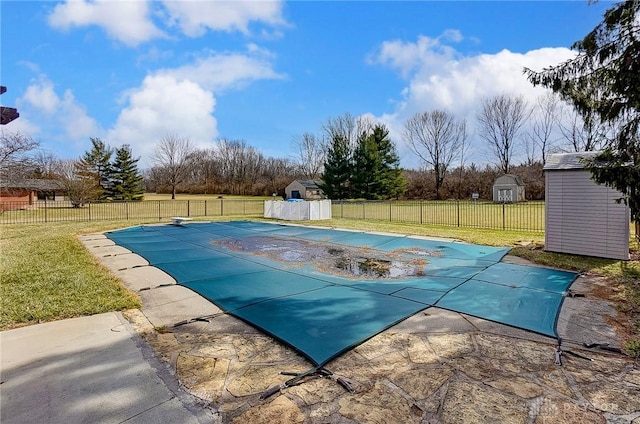 view of pool featuring an outbuilding, a shed, a lawn, and fence