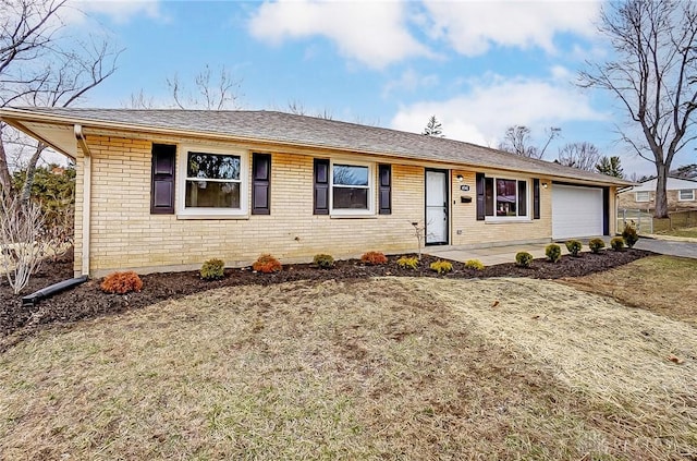 single story home featuring brick siding, an attached garage, and driveway