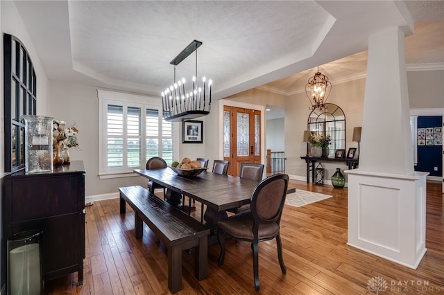 dining area featuring a chandelier, hardwood / wood-style floors, and a raised ceiling