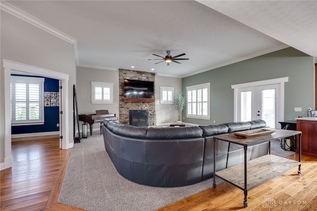 living room with plenty of natural light, light wood finished floors, a fireplace, and baseboards