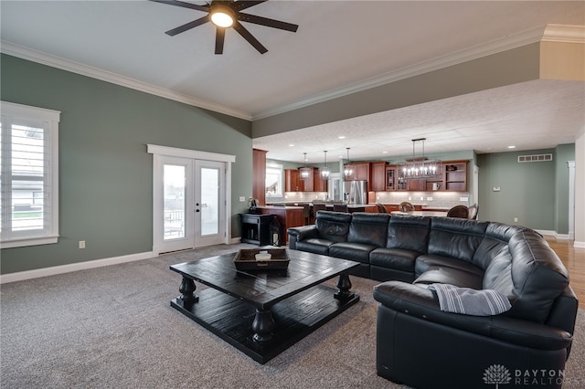 living area with french doors, visible vents, crown molding, and baseboards