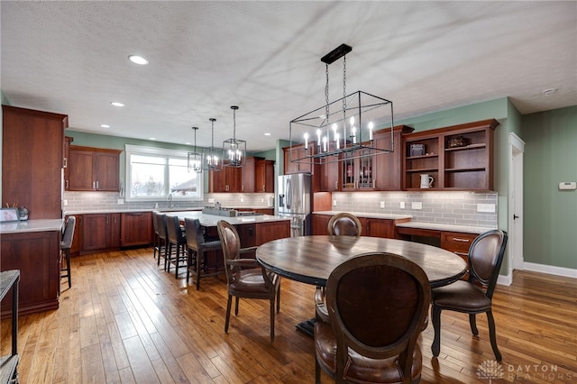 dining area featuring recessed lighting, baseboards, a textured ceiling, and light wood finished floors