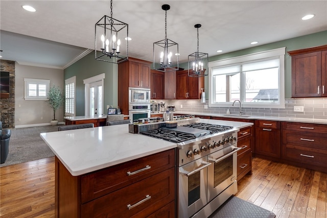 kitchen featuring stainless steel appliances, a sink, open floor plan, a center island, and tasteful backsplash