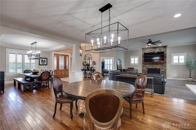 dining room with light wood finished floors, plenty of natural light, baseboards, and crown molding