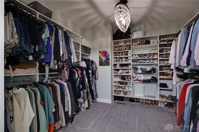 spacious closet featuring carpet flooring and a notable chandelier