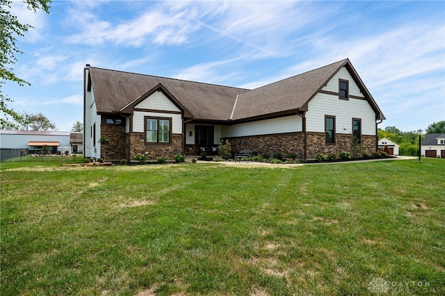 view of front of house with stone siding, a front lawn, and fence