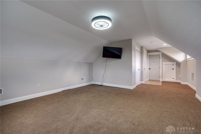 additional living space featuring carpet, vaulted ceiling, and baseboards