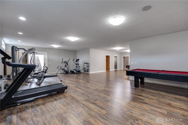 interior space with a textured ceiling, wood finished floors, and baseboards