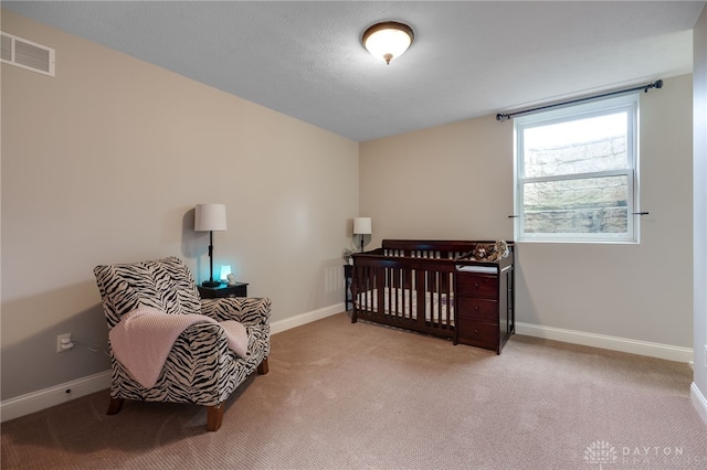 bedroom with carpet floors, visible vents, a textured ceiling, and baseboards