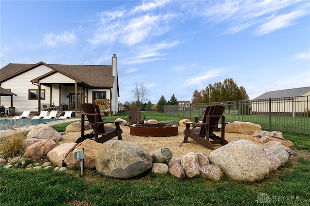 view of yard featuring a fire pit, fence, a fenced in pool, and a patio