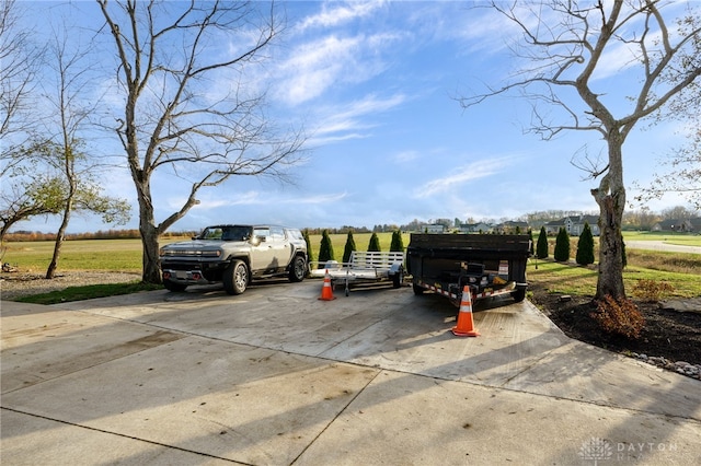 view of parking / parking lot with driveway and a rural view