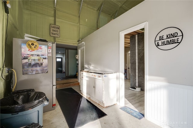 kitchen featuring freestanding refrigerator and a wainscoted wall