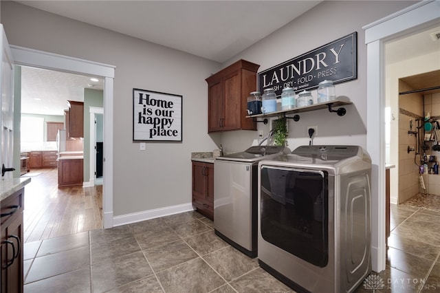 washroom featuring cabinet space, independent washer and dryer, visible vents, and baseboards