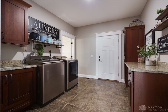 laundry room with cabinet space, baseboards, and washing machine and clothes dryer