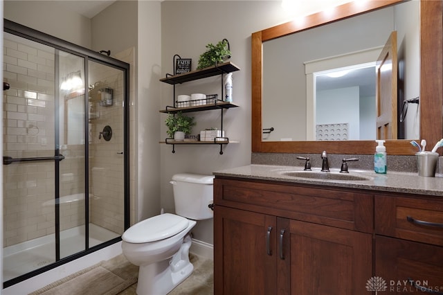 full bathroom featuring toilet, a shower stall, and vanity