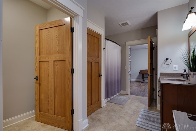 full bath with a shower with shower curtain, visible vents, vanity, and baseboards